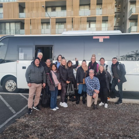 a group of people standing in front of a bus