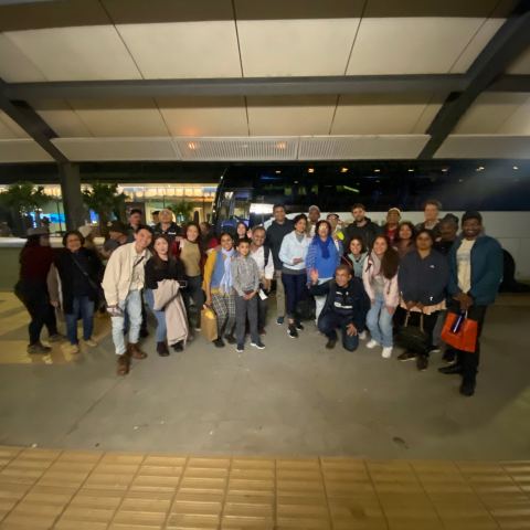 a group of people waiting for their luggage at an airport