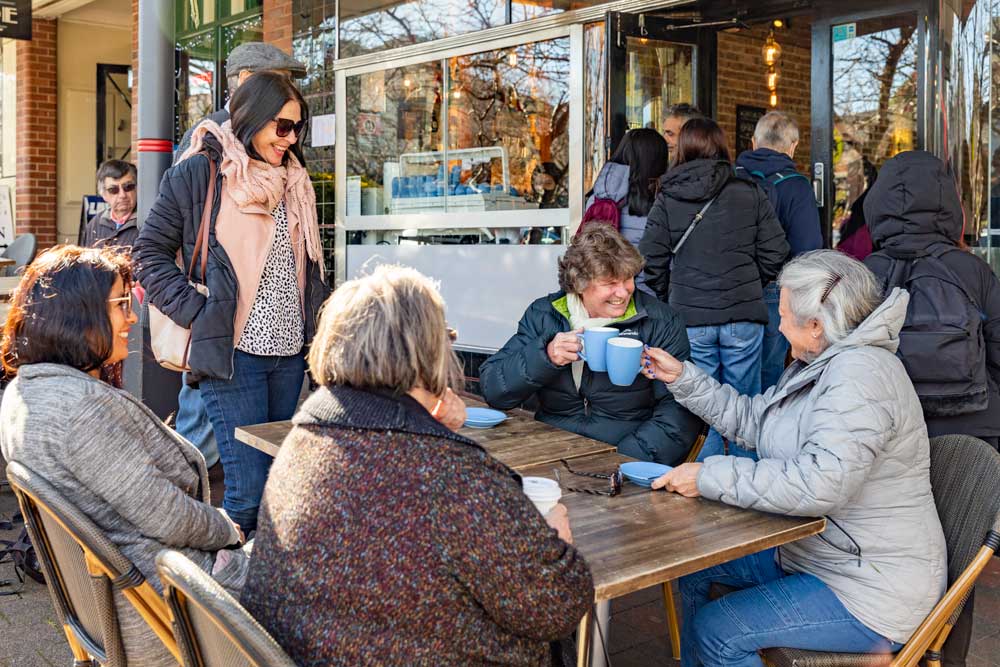 a group of people sitting in a chair talking on a cell phone