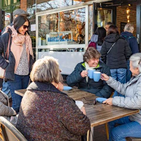 a group of people sitting in a chair talking on a cell phone
